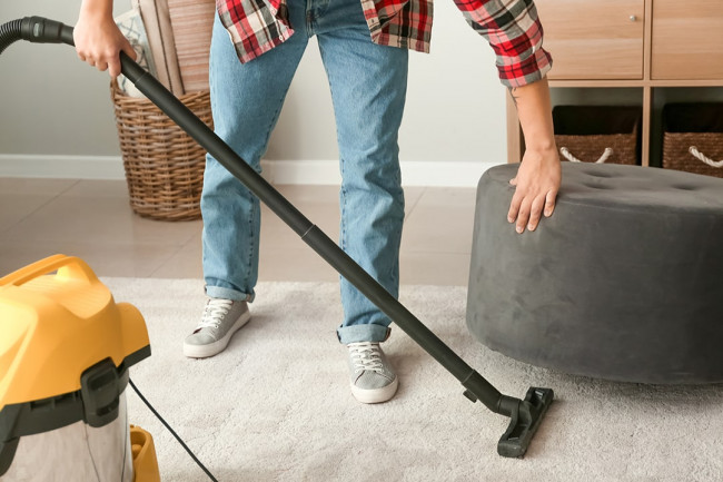 young asian man hoovering floor home prima tanza affordable condo for sale in cavite min