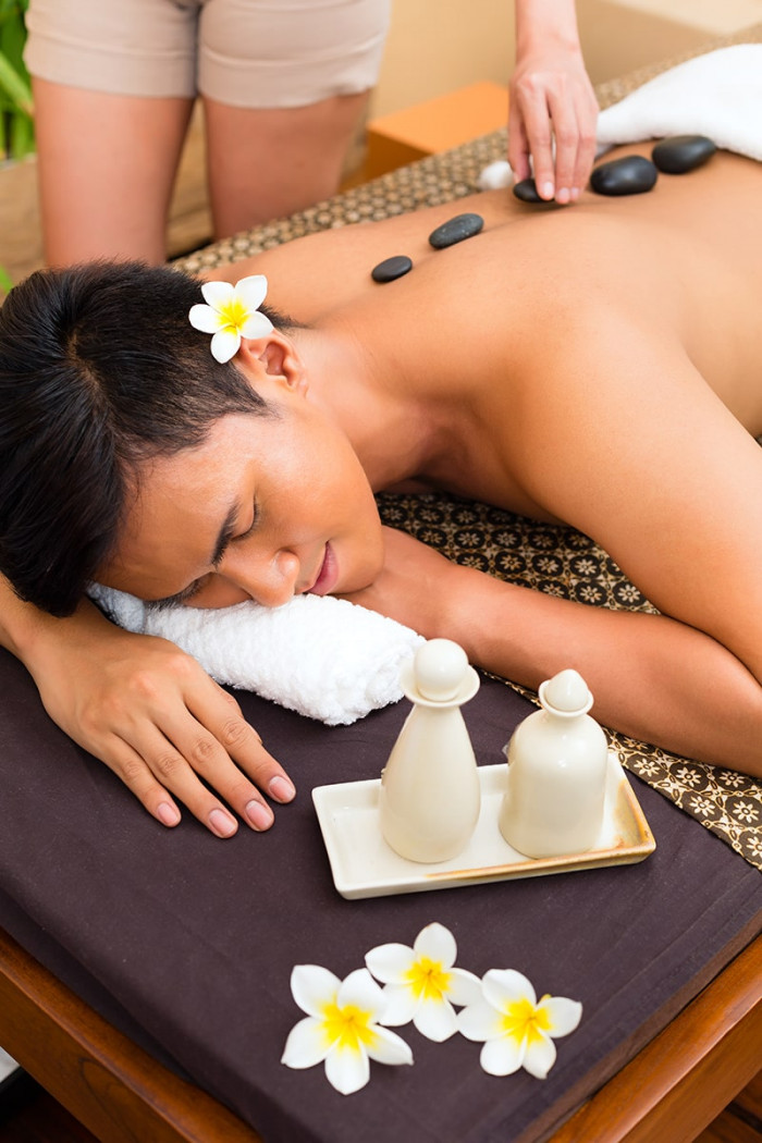 asian man wellness beauty day spa having hot stone massage treatment looking relaxed min
