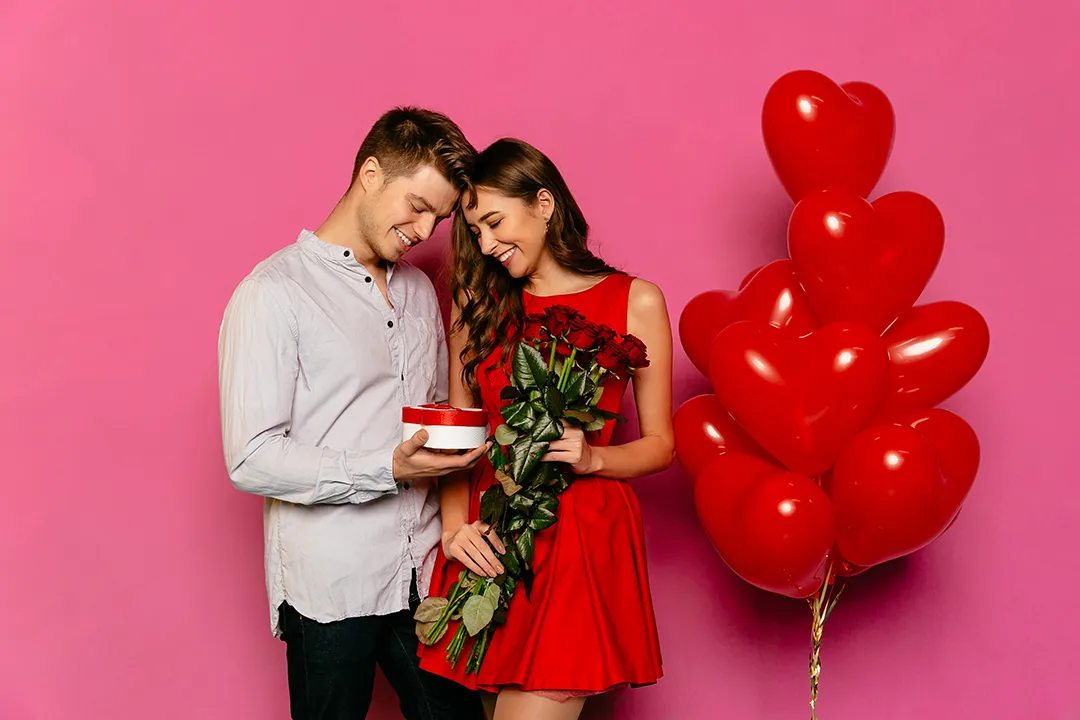 handsome man attractive woman looking box with gift red roses